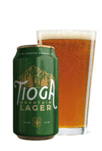 Green Tioga Mountain Lager 12oz can with glass of beer next to it